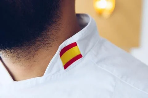Chef with a beard wearing a work jacket with the Spanish flag Stock Photos