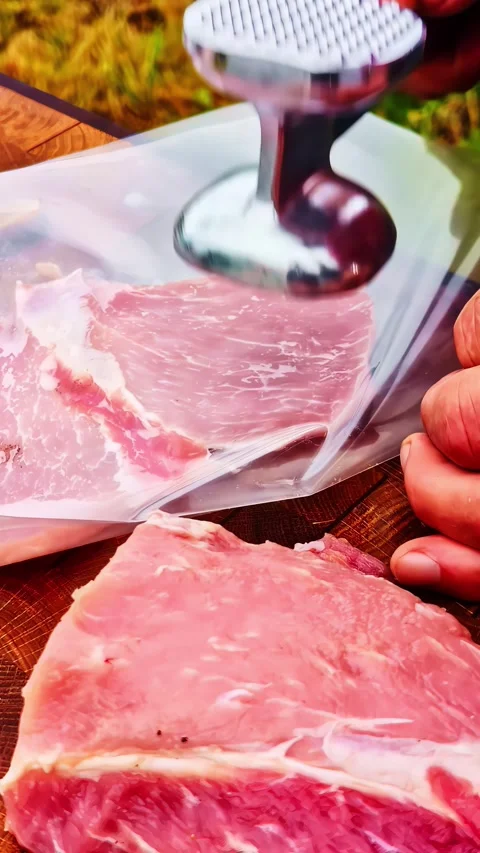 Chef beating raw pork with meat tenderizer mallet Stock Footage 336297214