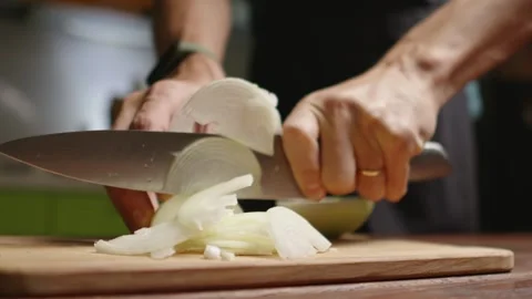 The chef in black apron cuts an onion with a knife Stock Footage 294540647