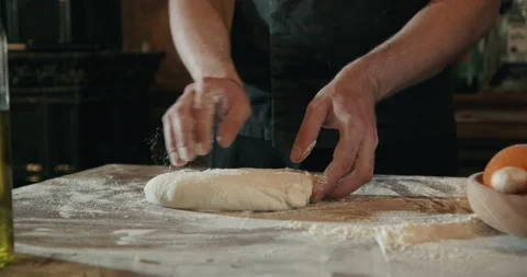 Chef in black apron, kneading dough for pizza by hands Stock Footage 201467741
