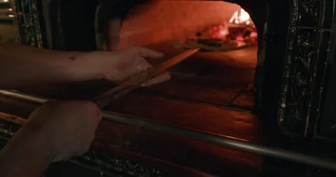 Chef in black apron, putting pizza margarita in the wood-burning oven Vídeo Stock 201467871