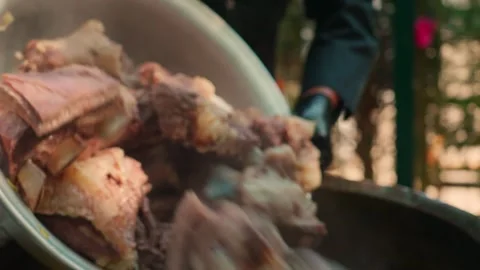 Chef in Black Gloves Adding Large Meat Chunks to Old Metal Kazan for Pilaf Stock Footage 332643607