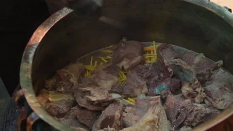 Chef in Black Gloves Adding Large Meat Chunks to Old Metal Kazan for Pilaf Stock Footage 346614023