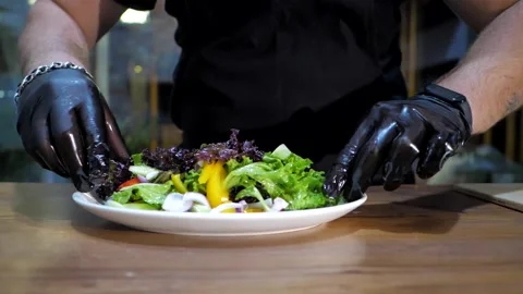 Chef in black gloves adjusts salad with his hands before giving 스톡 동영상 201550889