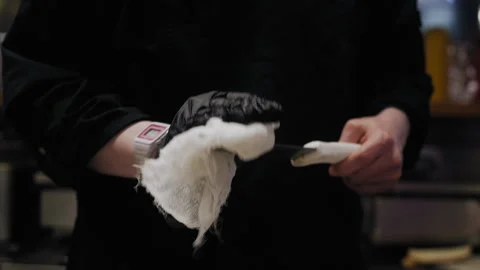 Chef in Black Gloves Cleaning Kitchen Knife with White Cloth Video stock 307088386
