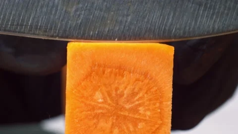 Chef in black gloves cut orange carrot on square pieces. Marco shot of cutting Stock-Footage 150772187