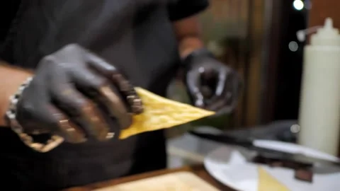 Chef in black gloves decorates salad with flatbread Stock Footage 201381425