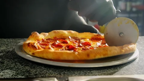 Chef in black gloves divides pizza into equal slices Stock Footage 326371381