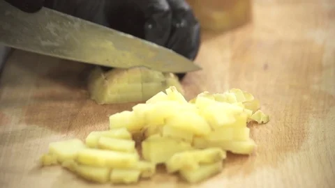 Chef in black gloves with a knife cuts the damage of boiled potatoes Stock Footage 71529343