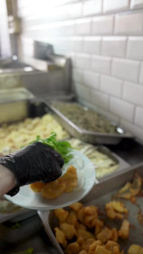 Chef in black gloves plating fried fish in a restaurant Stock Footage 324867040