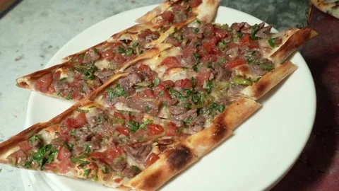 Chef in Black Gloves Serving Sliced Turkish Pide with Diced Meat on Plate Stock Footage 323183079