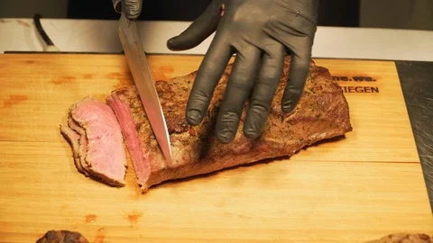 The chef in black gloves slice the meat 4k Video stock 121172131