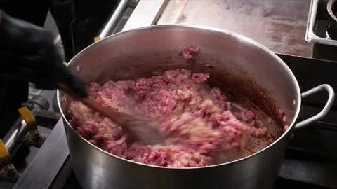 Chef in Black Gloves Stirring Raw Ground Beef and Onions in Large Pot Stock Footage 331634169