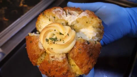 Chef in Blue Gloves Holding Freshly Baked Viral Korean Cream Cheese Garlic Bread Video stock 343587545