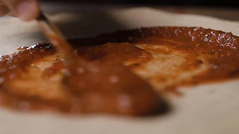 The chef blurs the sauce over the dough with a spoon Stock Footage 124275894