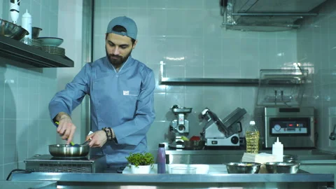 Chef bothers to salt the vegetables in the pan Stock Footage 87554385