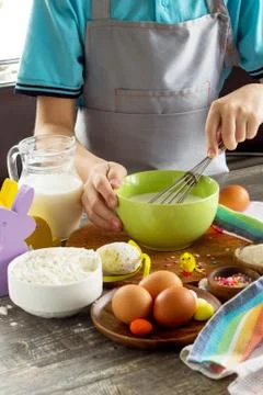 Chef boy cooking on a Easter kitchen table and cooking dough. Food background. Stock Photos
