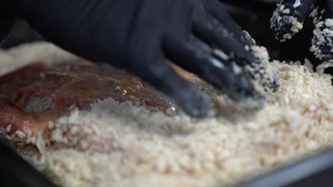 Chef breading raw meat with panko for a delicious crispy schnitzel or cutlet Stock Footage 338013607