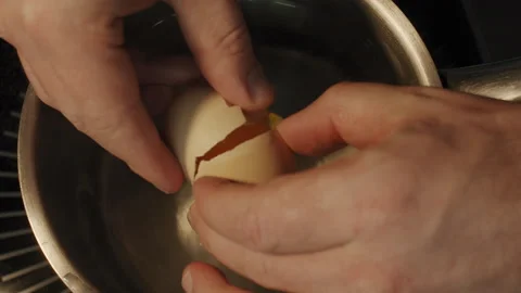 Chef break an egg into boiling water in a metal ladle on a stove in slow motion Stock-Footage 150762580