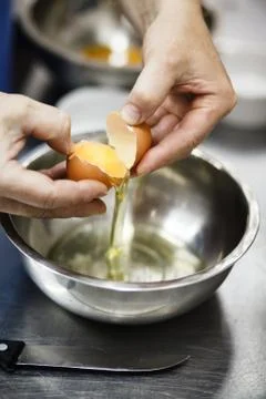 The chef breaks egg in a cup Stock Photos