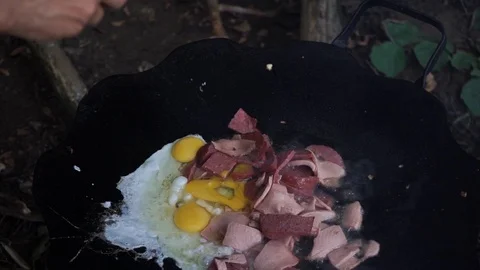Chef breaks egg in frying pan, cooking omelette with meat Stock Footage 114631279