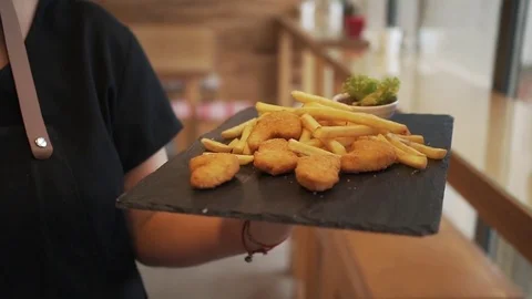 Chef is bringing out food to the customer. Chicken nuggets with french fries in Stock Footage 85145681