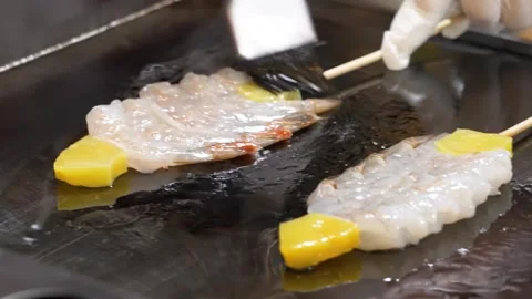 Chef Brushing Oil on Fresh Shrimp and Mango Skewers on Teppanyaki Griddle Stock Footage 337440656