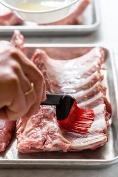 Chef brushing raw beef ribs with marinade Stock Photos