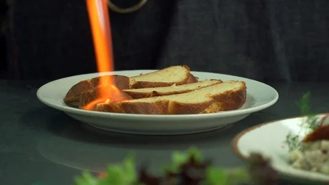 Chef burns bread in the restaurant. To make the bread crispy and hot. Flame of Stock Footage 110791803