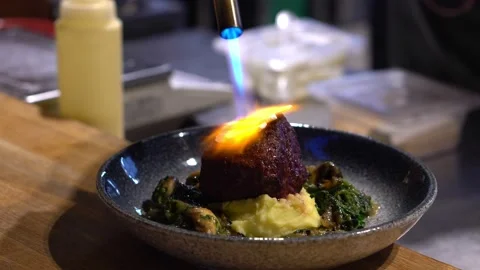 The chef burns a meat dish with fire. An exclusive dish from the chef of the Video stock 171682518