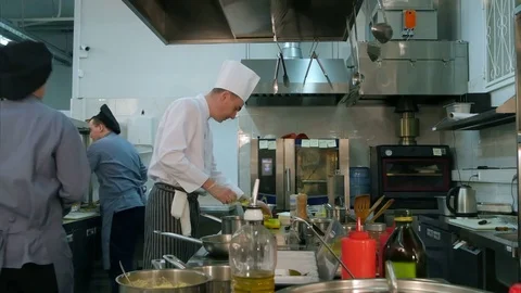 Chef buttering bread before toasting and talking to cook trainee Vídeo Stock 72323069