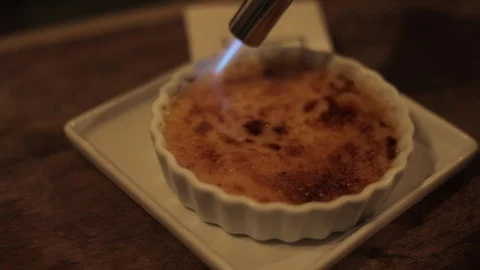 Chef Caramelizing Creme Brulee with Torch Stock Footage 129333979