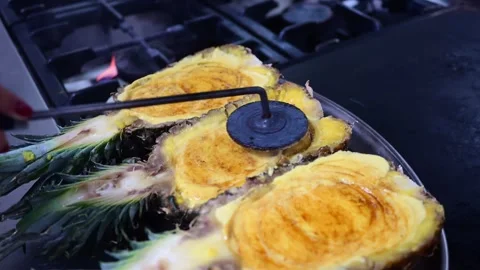 Chef caramelizing halved pineapples with hot iron stamp Video stock 325561647