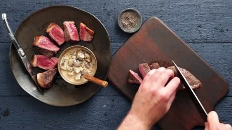 A chef carefully cuts a steak, resulting in a perfectly cut. animated 4k HD 库存影片 336581843