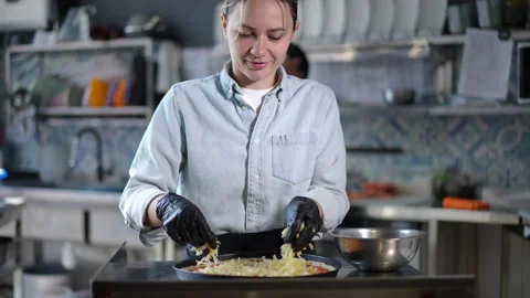 Chef carefully preparing a delicious pizza while working in a modern kitchen Stock Footage 296633962