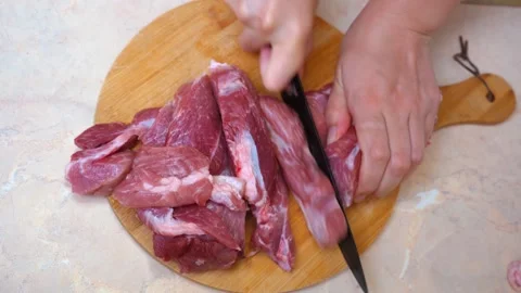 Chef carefully slices marbled meat into even strips for stew Stock Footage 330021735