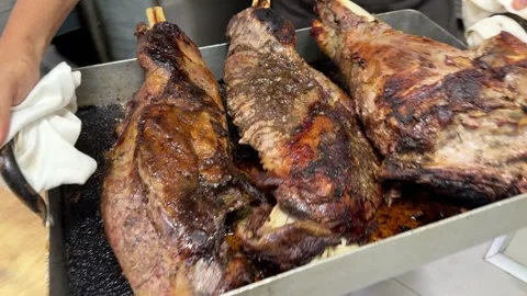Chef carrying roasted lamb shoulders in a professional kitchen Video stock 344100010