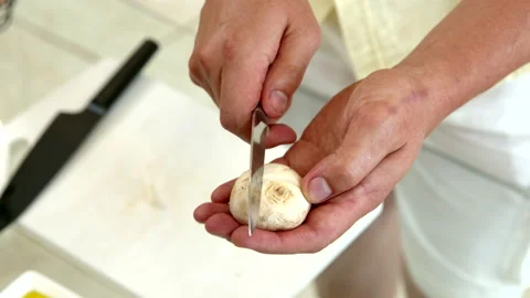 Chef carves pattern on champignons before frying for beautiful decoration Stock Footage 141256980