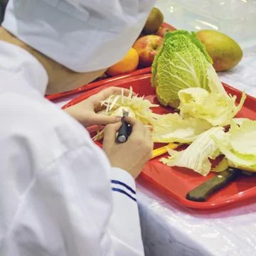 Chef carves patterns on cabbage and other vegetables and fruits for a beautif Stock Photos