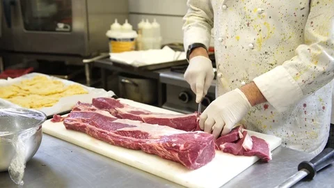 A chef carving the meat for the steaks in his kitchen in Italy, 4K Stockbeeldmateriaal 72241597
