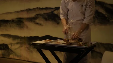 Chef Carving Poultry Tableside in Beijing Restaurant with Artistic Wall Stock Footage 345765779