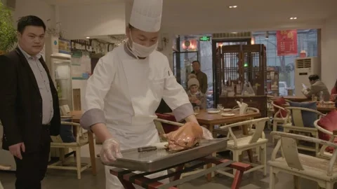 Chef Carving Roast Duck for Diners at Restaurant Table in Beijing, China Stock Footage 345900790
