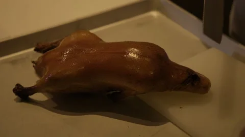 Chef Carving Roasted Poultry in Beijing Restaurant Kitchen for Food Preparation Stock Footage 345765344