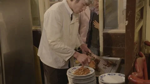 Chef Carving Roasted Poultry at Restaurant Counter in Busy Beijing Kitchen Scene Stock Footage 345773190