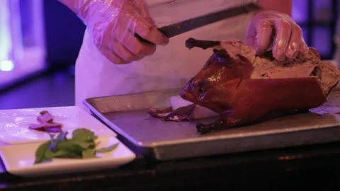 Chef Carving Roasted Poultry at Table in Beijing Restaurant with Fresh Herbs Stock Footage 345744163