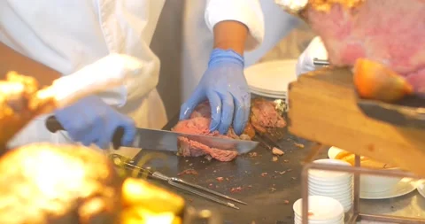 Chef carving slice of roast meat and serving in a plate to a guest. Catering Video stock 154932929