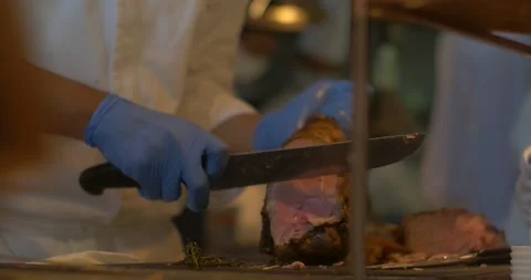 Chef carving slice of roast meat. Catering service during wedding, event or Stock-Footage 154933595