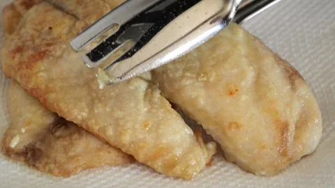 Chef checking fried fish fillet doneness with fork in slow motion Stock Footage 305941073