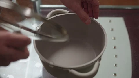 Chef checking glass lid on new non-stick coated aluminum pan, preparing to Stock Footage 306701538