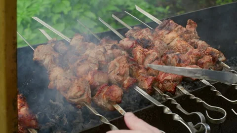 Chef checking meat temperature with knife while grilling pork shish kebabs Stock Footage 296722312